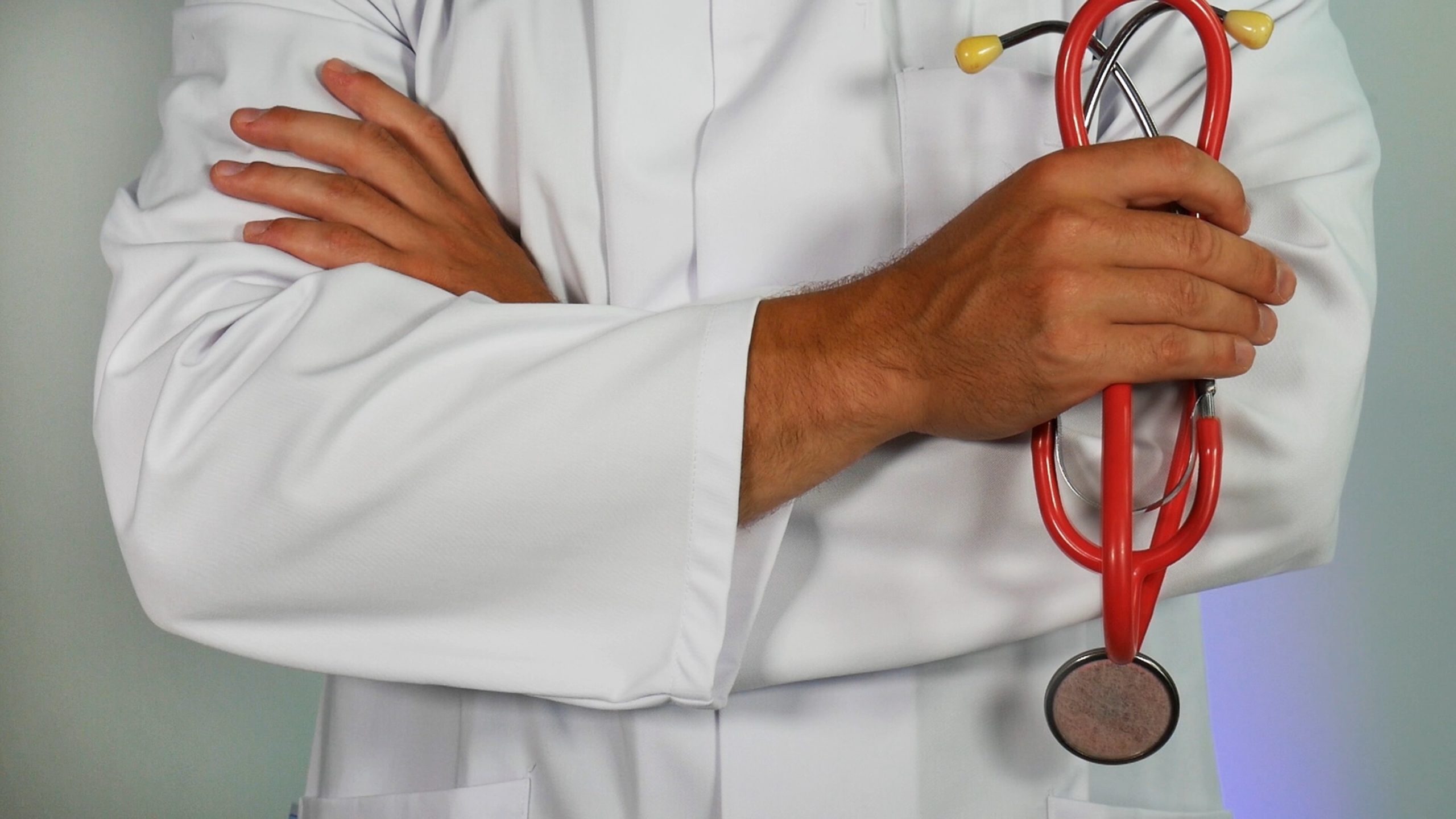 doctor with their arms crossed and holding a stethoscope